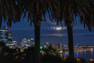 Obraz na płótnie Canvas Ciudad de Noche. Panoramica. Captada desde lejos. Luna llena escondida detras de las nubes