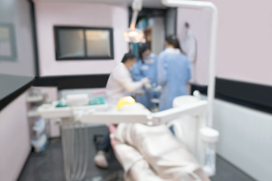 Blurred image photo of dentist and his assistant are working in clinic.