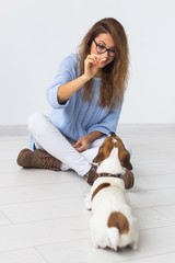 Pets owner concept - Attractive cheerful female in blue sweater playing with her favourite pet....