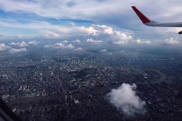 Obraz premium red winglet in graduated dark blue sky with a view of big city below in sunshine