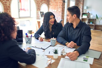 Young beautiful couple applying for mortgage. Sitting smiling happy meeting with real state agent...