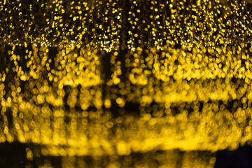 many of bokeh from light bulb tube on a street at night that look like luxury golden star light in dark background