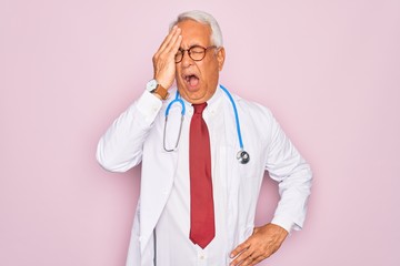 Middle age senior grey-haired doctor man wearing stethoscope and professional medical coat Yawning...
