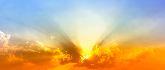 colorful sunshine light in blue sky with clouds and bright red orange and yellow color light
