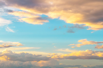 Fototapeta premium soft yellow light in light blue sky with fluffy clouds
