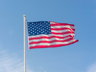 Flag of the United States on the blue sky.