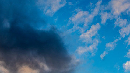Naklejka na ściany i meble A storm cloud encroaches on blue sky
