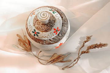 Old vintage box with an unusual ornament petals,  dry branches of herbarium white chiffon background