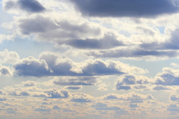Obraz premium Clouds in the blue sky at sunset or dawn backlit by the sun. Place for text and design.