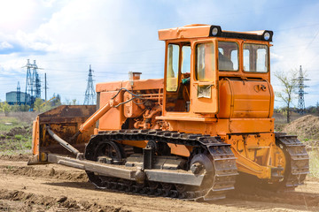 Industrial building construction site bulldozer leveling and moving soil during highway building