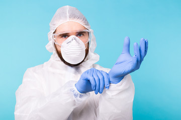 Professional for disinfection efforts. Epidemiologist man puts on protective suit and gloves. Coronavirus, covid-19 and pandemic concept.