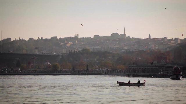Traditional Sunset view of Golden Horn in Istanbul while Boat and Seagulls Passing by Slowly