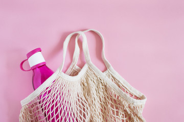 Fototapeta premium Reusable shopping bag with bottle on color background.