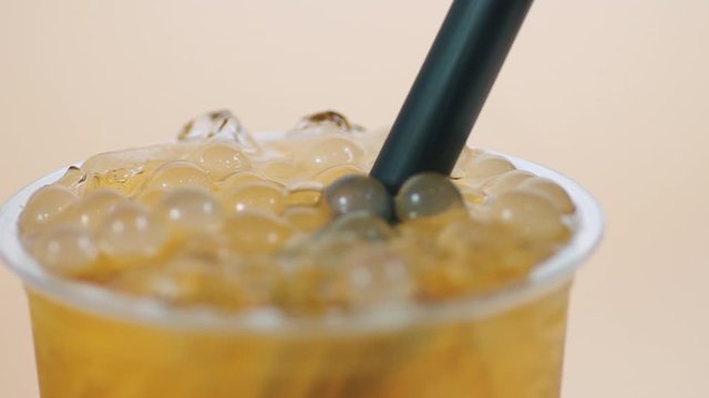 put a straw on bubble tea , close up