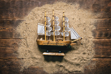 Ship on the sand on brown flat lay abstract background.