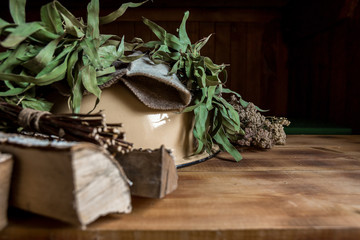 Interior details Finnish sauna steam room or Russian bathhouse with traditional sauna accessories: basin, birch broom, felt hat, birch wood medicinal herbs . Relax concept. Copy space