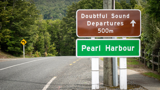 Roadsign on the side of the road reading Doubtful Sound and Pearl Harbour, shot in Fiordland National Park, New Zealand
