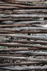 The texture of a beautiful wicker fence made of dry branches that lie tightly together. Wooden background