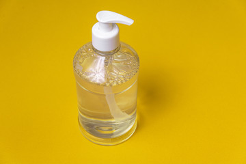 Container with alcohol gel on the orange background