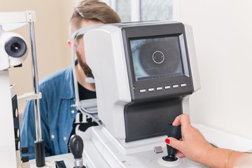 Fototapeta premium Medicine, health, ophthalmology concept - patient checks her vision by an ophthalmologist.