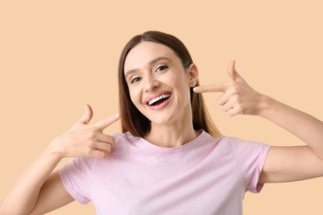 Young woman with beautiful smile on color background