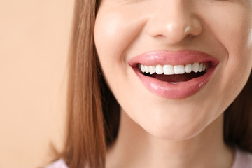 Young woman with beautiful smile on color background, closeup