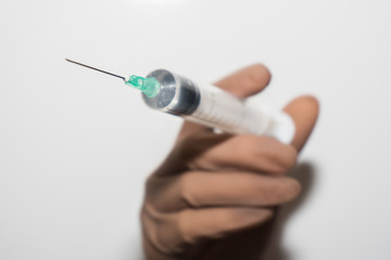 Syringe in the doctor&rsquo;s hand in a medical rubber glove. The doctor is vaccinated. Coronavirus vaccine covid-19 2019-ncov