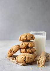 Buckwheat healthy cookies with raisin and nuts with a glass of milk. Light grey concrete background. Selective focus. 
