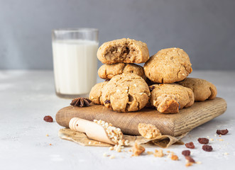 Buckwheat healthy cookies with raisin and nuts with a glass of milk. Light grey concrete background. Selective focus. 
