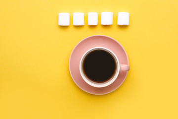 Cup of coffee with marshmallows on color background
