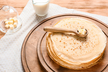 Tasty blini with butter on table