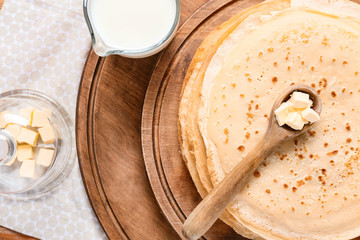 Tasty blini with butter on table