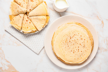 Tasty blini with milk on table