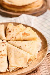 Plate with tasty blini on table, closeup