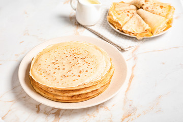 Plate with tasty blini on table