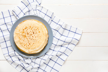 Plate with tasty blini on table