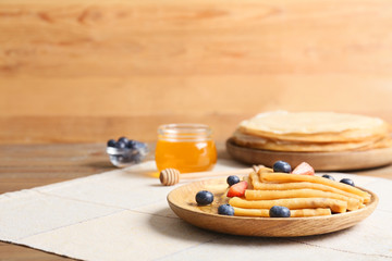 Tasty blini with berries on table