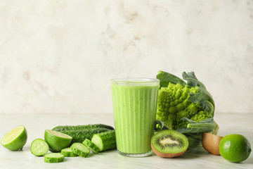 Glass of healthy smoothie and ingredients on table