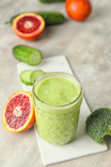 Glass of healthy smoothie and ingredients on table