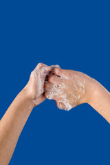 Kid washing hands with soap to stop spreading virus infection, on blue background