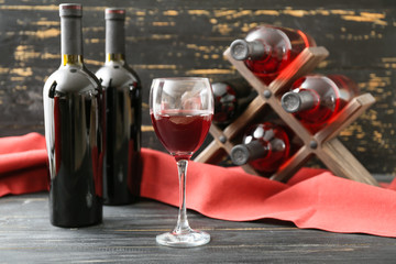 Bottles and glass of wine on table