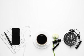 Composition with cup of coffee, mobile phone, clock and notebook on white background