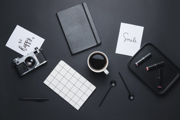 Composition with cup of coffee and different items on black background