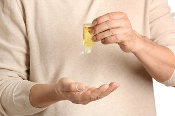 Man using sanitizer on white background, closeup