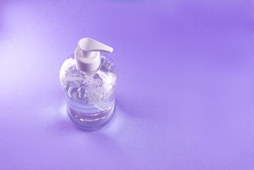 Container with alcohol gel on the light blue background