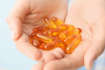 Woman with fish oil capsules, closeup