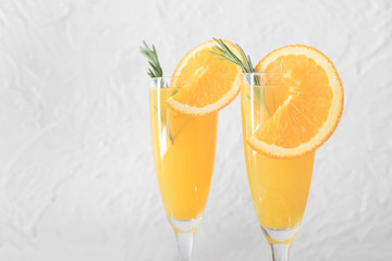 Glasses of tasty mimosa cocktails on light background