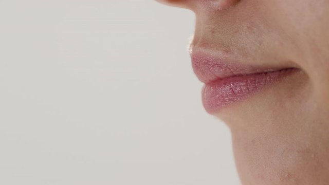 
Extreme close-up of a female mouth sticking her tongue out and then pursing her lips in a kiss gesture.
