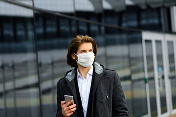 Young man in a medical mask outside, no money, crisis, poverty, hardship. Quarantine, coronavirus, isolation.