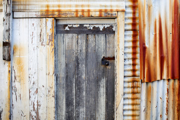 Rusty corrugated iron building wall and timber door